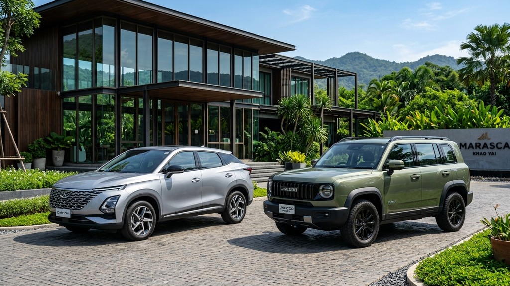 Chery Omoda C9 สีเงิน จอดคู่กับ Jaecoo 7 PHEV สีเขียวมะกอก ด้านหน้ารีสอร์ตหรูสไตล์กระจกโมเดิร์นในเขาใหญ่ ประเทศไทย