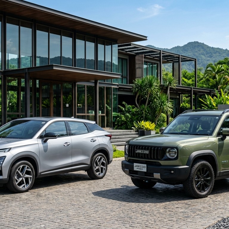 Chery Omoda C9 สีเงิน จอดคู่กับ Jaecoo 7 PHEV สีเขียวมะกอก ด้านหน้ารีสอร์ตหรูสไตล์กระจกโมเดิร์นในเขาใหญ่ ประเทศไทย