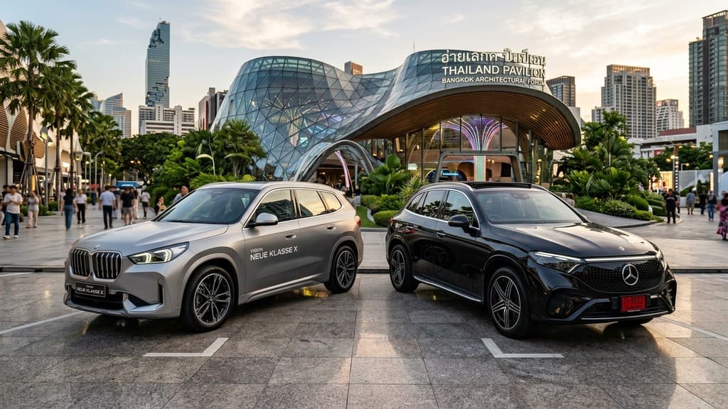 BMW iX3 Neue Klasse X สองโทนสีบรอนซ์ จอดคู่กับ Mercedes-Benz GLC EV สีดำ หน้าอาคารแสดงสถาปัตยกรรมกรุงเทพฯ